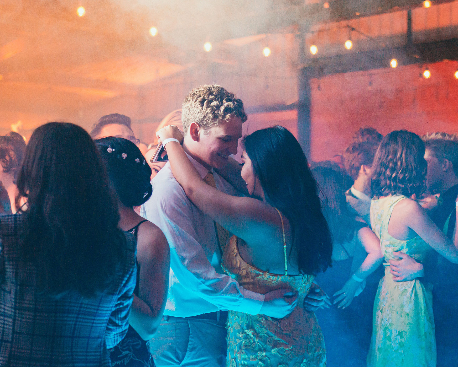 Couples dansant en duo lors du bal d'un mariage dans une ambiance festive et chaleureuse.