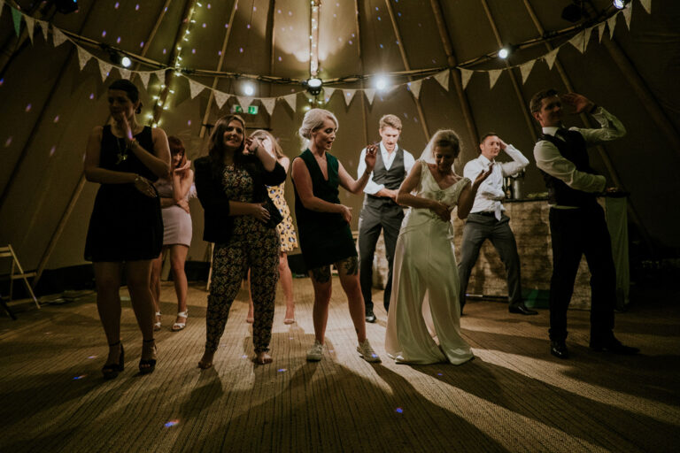 Convives dansant sur la piste de danse lors du mariage.