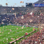 Une foule enthousiaste lance des prospectus sur le terrain de foot.